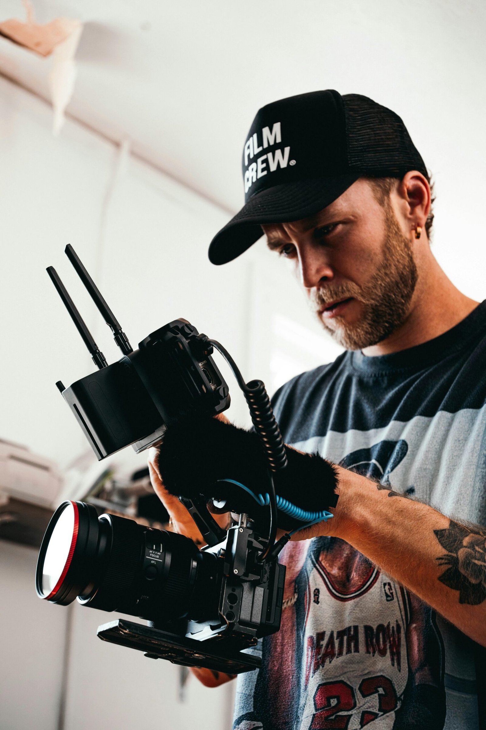 Cinematographer in action adjusting camera equipment on set indoors.